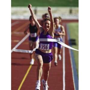 Female Runner Victorious at the Finish Line in a Track Race 